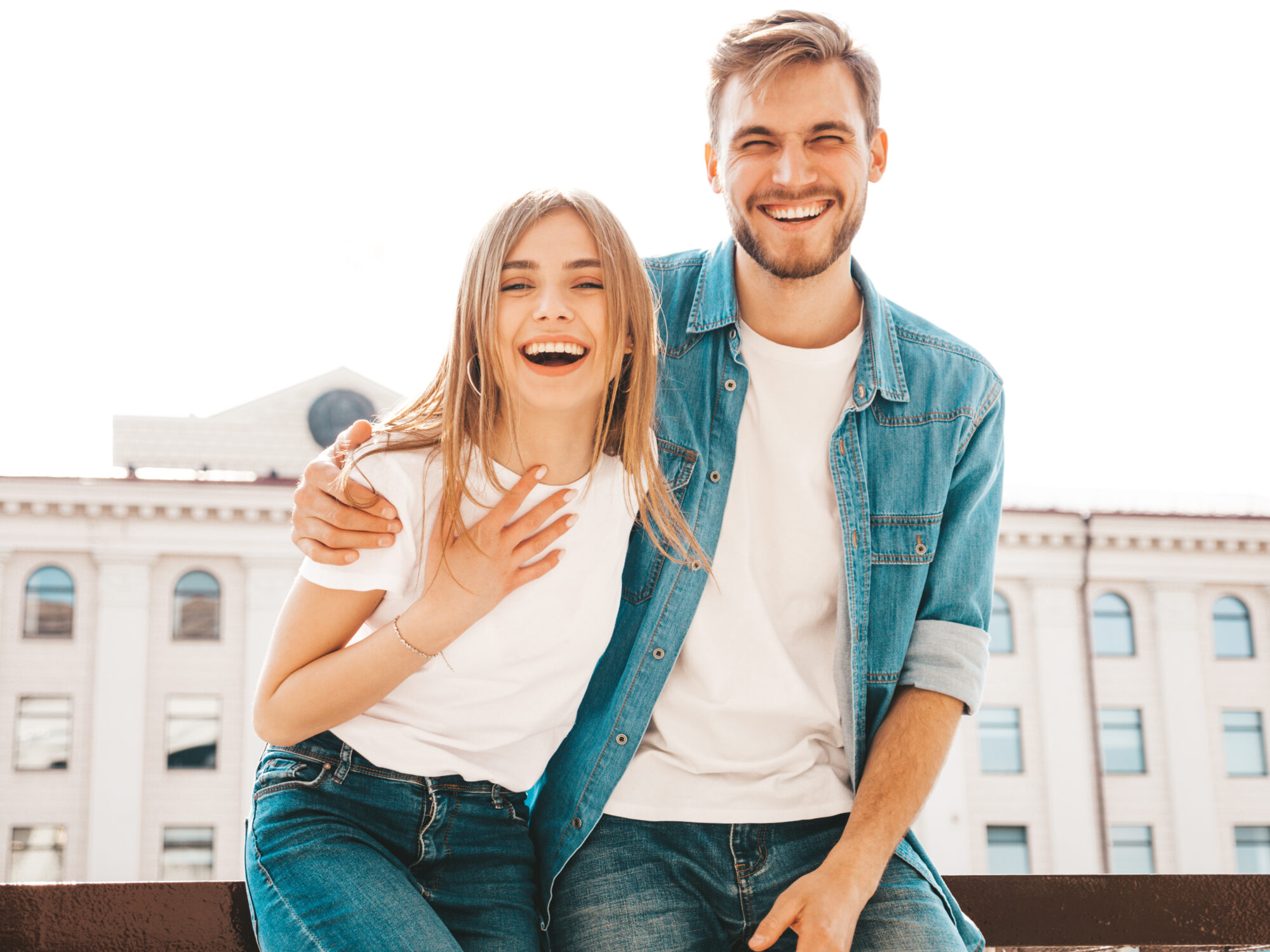 Smiling beautiful girl and her handsome boyfriend in casual summer clothes. Happy cheerful family having fun on the street background