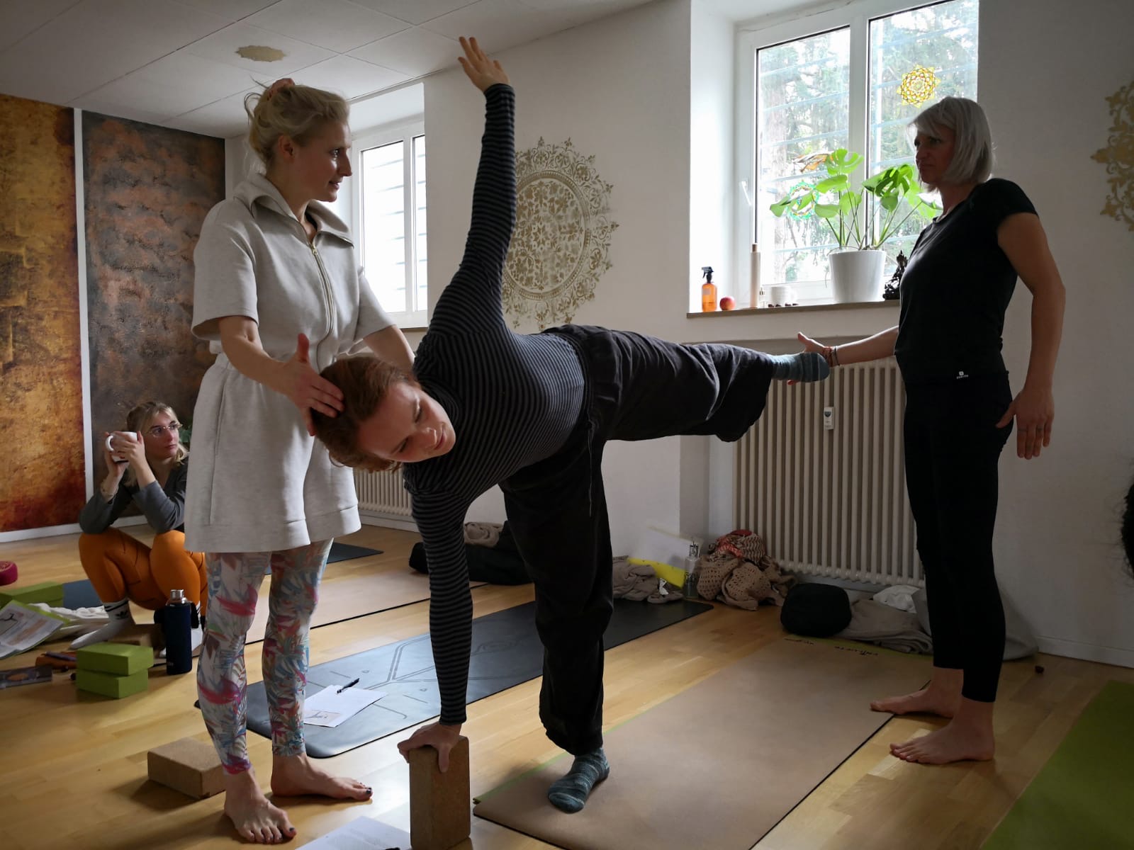 a group of people sitting on mats with hands together